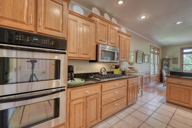 kitchen featuring light tile patterned floors, appliances with stainless steel finishes, sink, and crown molding