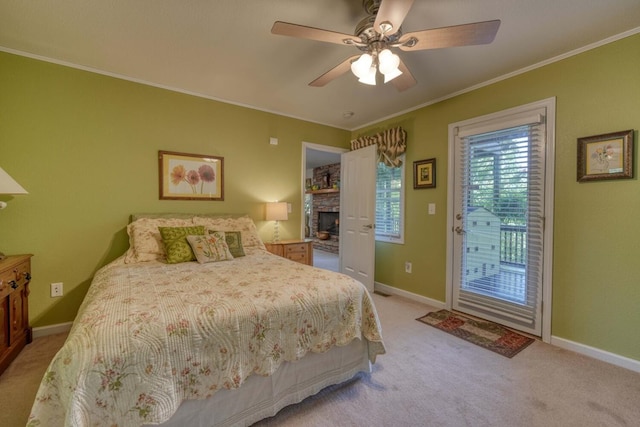 bedroom featuring crown molding, access to outside, ceiling fan, a stone fireplace, and light carpet