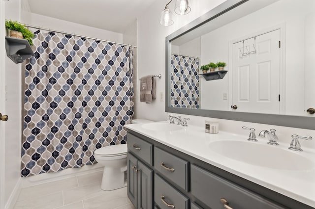 bathroom with toilet, vanity, and tile patterned floors