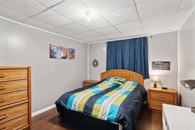 bedroom with dark hardwood / wood-style flooring and a drop ceiling