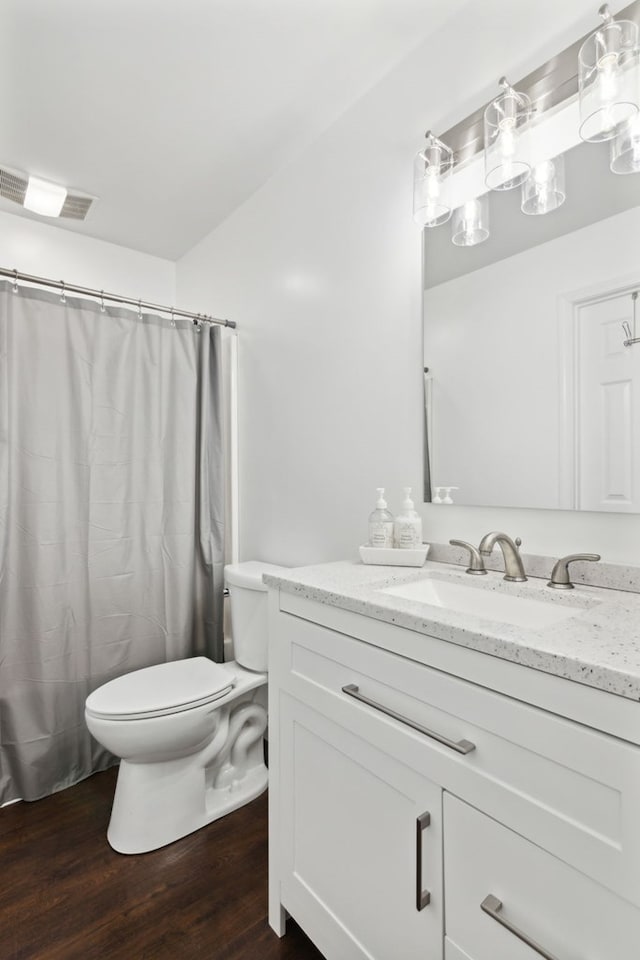 bathroom with wood-type flooring, vanity, and toilet