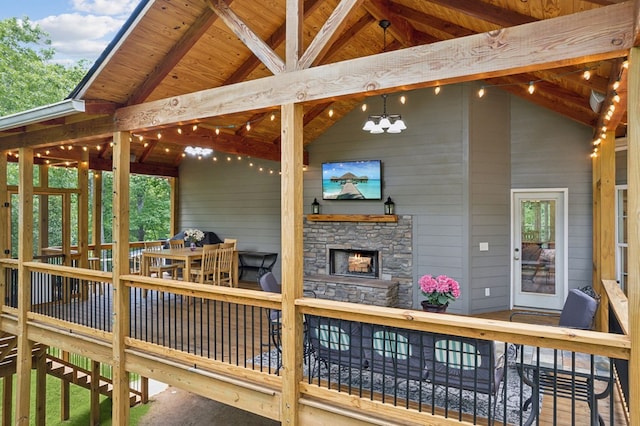 wooden terrace with an outdoor stone fireplace