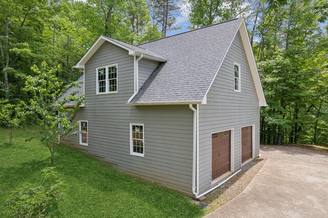 view of side of home with a lawn and a garage