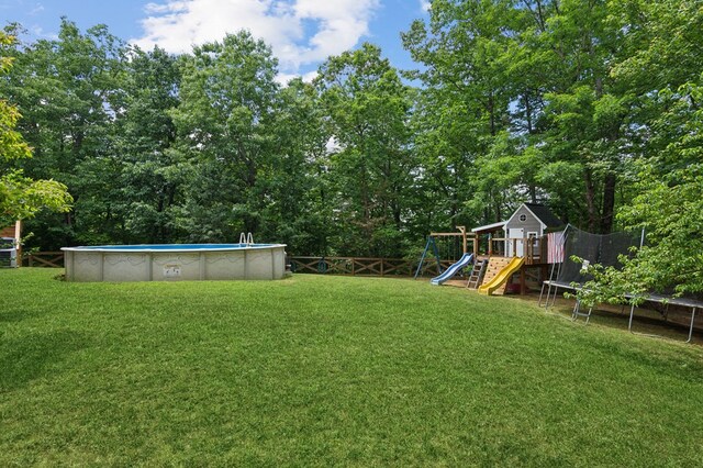 view of yard with a playground and a trampoline