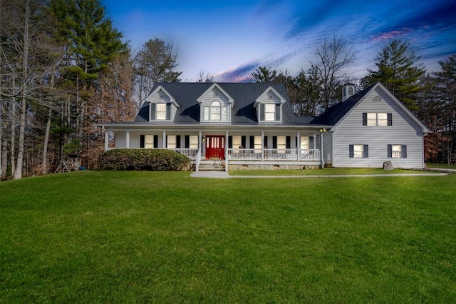 cape cod house with covered porch and a yard