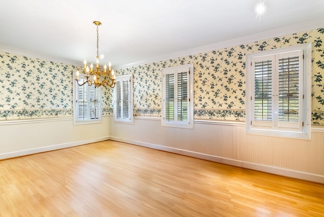 spare room with wood-type flooring, crown molding, and a wealth of natural light