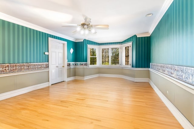 unfurnished room featuring ceiling fan, wood-type flooring, and crown molding