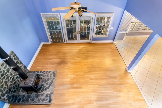 interior space featuring hardwood / wood-style flooring, ceiling fan, and a wood stove