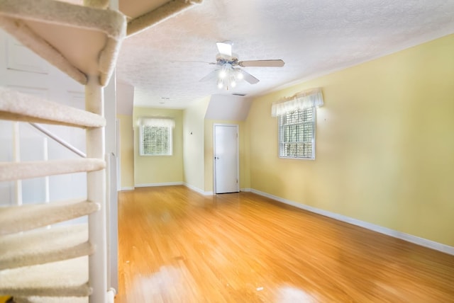 interior space with wood-type flooring, a textured ceiling, and ceiling fan