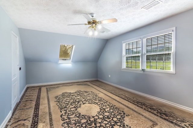 bonus room with carpet flooring, a textured ceiling, vaulted ceiling, and ceiling fan