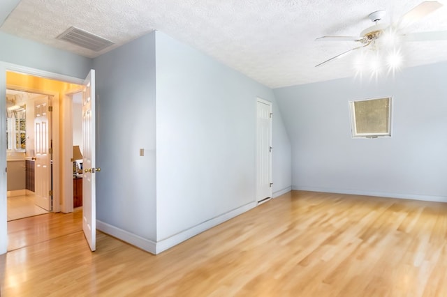 additional living space featuring wood-type flooring, a textured ceiling, and ceiling fan