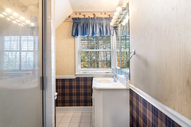 bathroom with tile patterned flooring, vanity, and a textured ceiling