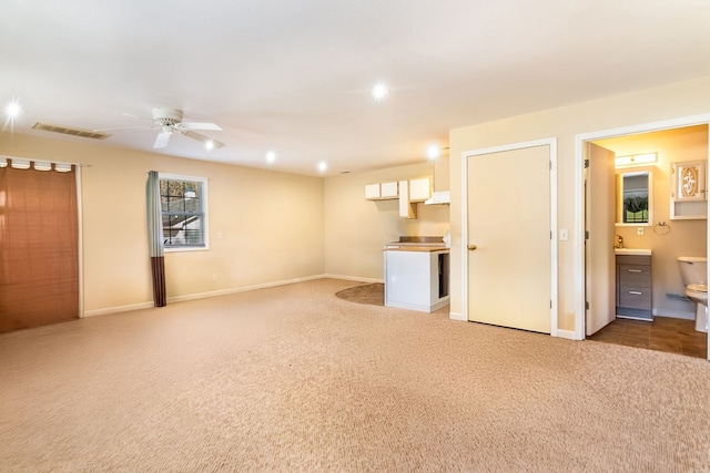 interior space featuring carpet flooring, ceiling fan, and sink