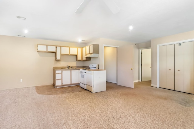 kitchen featuring ceiling fan, light colored carpet, white range with gas cooktop, and sink