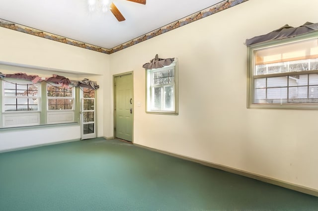 carpeted spare room with a wealth of natural light and ceiling fan