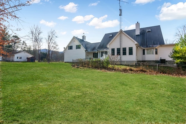 back of house featuring a lawn and central air condition unit