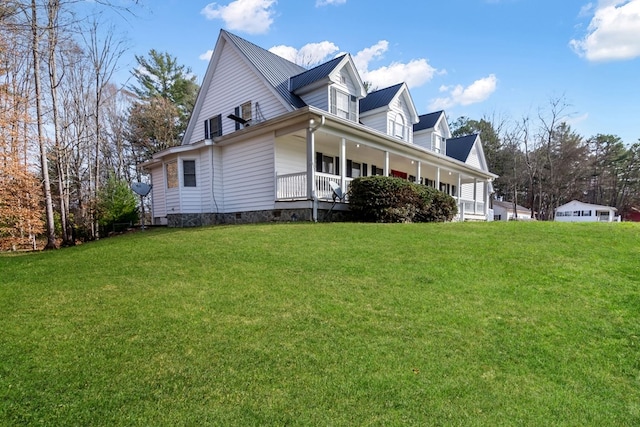 view of side of home with covered porch and a yard