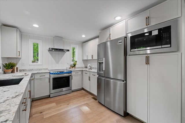 1220 Walnut Rdg, Ellijay, GA 30536 - kitchen featuring appliances with stainless steel finishes, light wood finished floors, light stone counters, wall chimney range hood, and recessed lighting