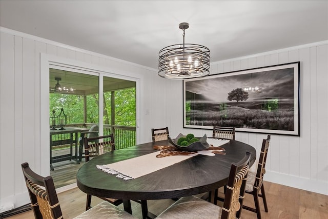 1220 Walnut Rdg, Ellijay, GA 30536 - dining room featuring wood finished floors, ornamental molding, a chandelier, a decorative wall, and baseboards