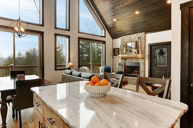 681 Confederate Cir, Murphy, NC 28906 - kitchen featuring open floor plan, wood ceiling, light stone counters, light wood-style flooring, and a fireplace
