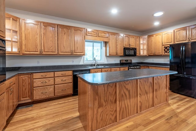 kitchen with light hardwood / wood-style floors, sink, black appliances, and a kitchen island