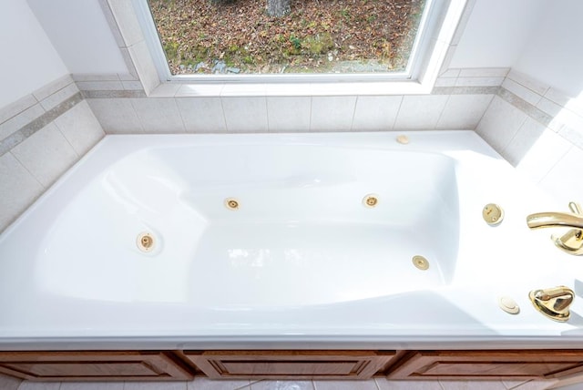 bathroom featuring tiled bath and plenty of natural light