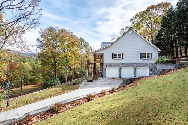 view of side of property featuring a garage and a lawn