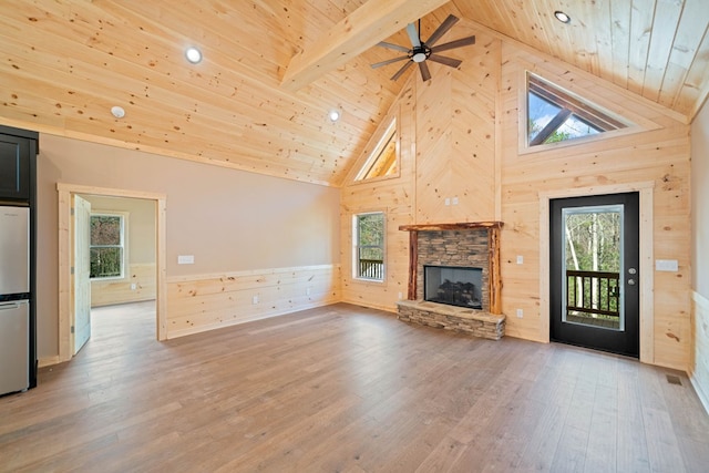 unfurnished living room featuring wooden ceiling, beamed ceiling, high vaulted ceiling, wood-type flooring, and a fireplace