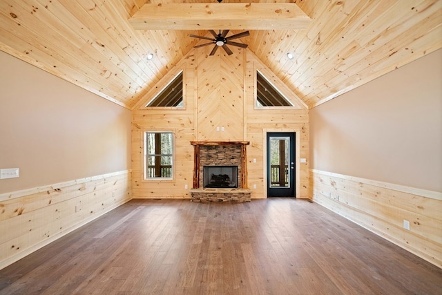 unfurnished living room featuring beam ceiling, plenty of natural light, wooden ceiling, and wood-type flooring