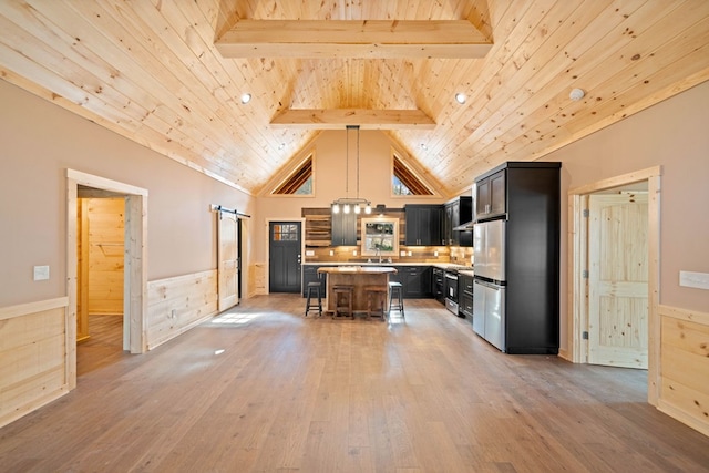 kitchen featuring a kitchen breakfast bar, light hardwood / wood-style flooring, beamed ceiling, a center island, and hanging light fixtures