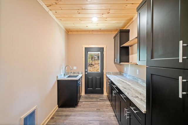 bar featuring light stone countertops, refrigerator, sink, wood-type flooring, and wooden ceiling