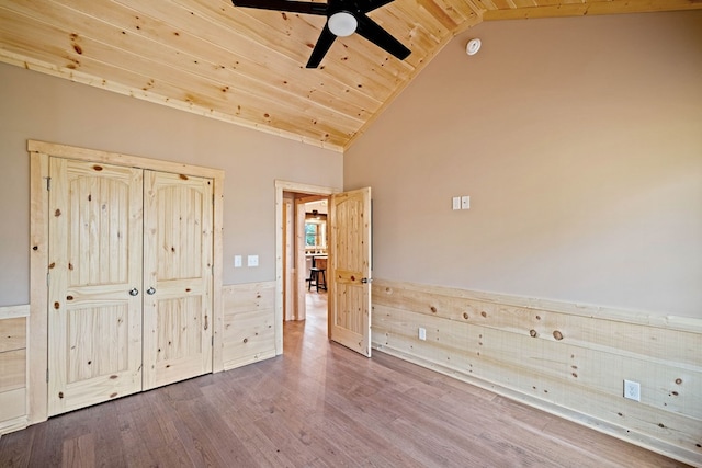 unfurnished bedroom featuring ceiling fan, hardwood / wood-style floors, high vaulted ceiling, and wooden ceiling