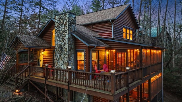 back house at dusk with a deck