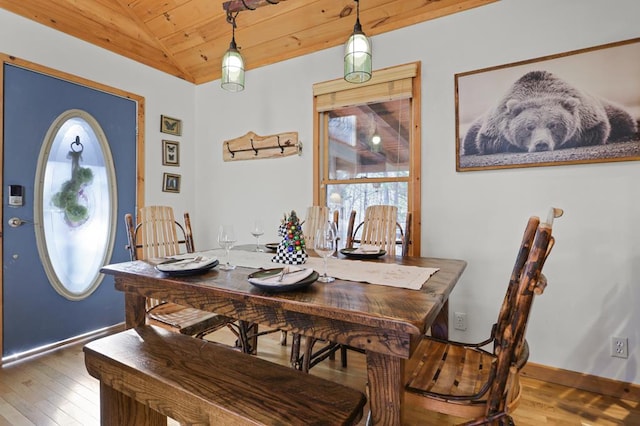 dining space featuring hardwood / wood-style floors, lofted ceiling, and wooden ceiling