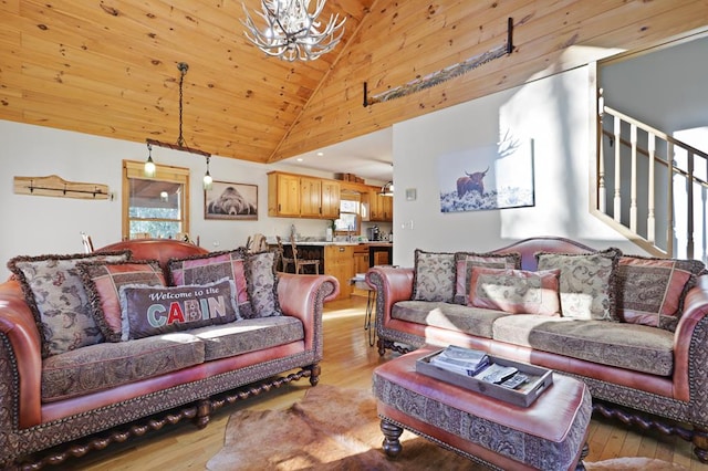 living room with high vaulted ceiling, light hardwood / wood-style floors, and an inviting chandelier