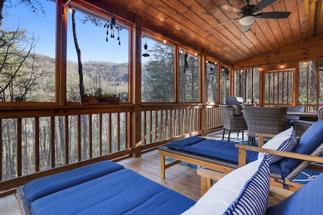 sunroom / solarium featuring lofted ceiling, ceiling fan, and wooden ceiling