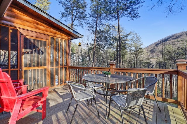 wooden terrace with a sunroom and a mountain view