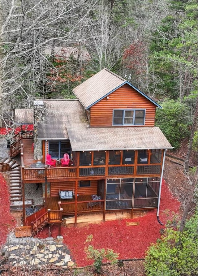 rear view of property with a sunroom and a wooden deck