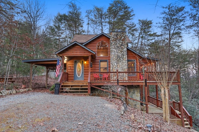 log-style house with a wooden deck