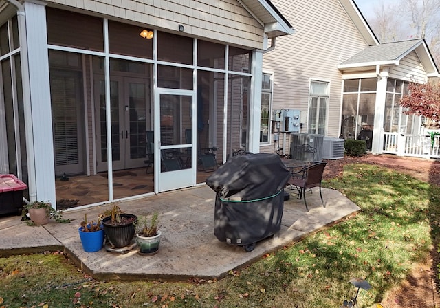 view of patio featuring area for grilling, central AC unit, and a sunroom