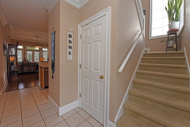 stairway featuring crown molding and tile patterned flooring