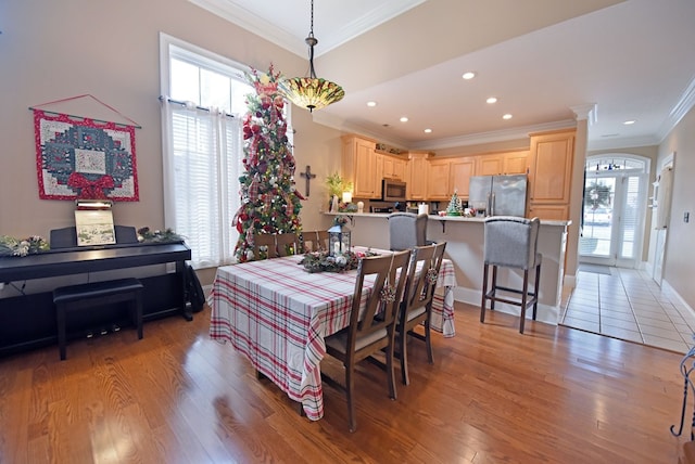 dining area featuring ornamental molding, plenty of natural light, and light wood-type flooring