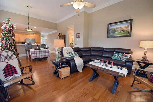 living room featuring ornamental molding, light hardwood / wood-style floors, and ceiling fan