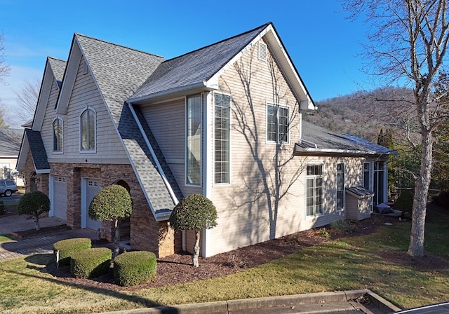 view of side of home featuring a garage and a yard