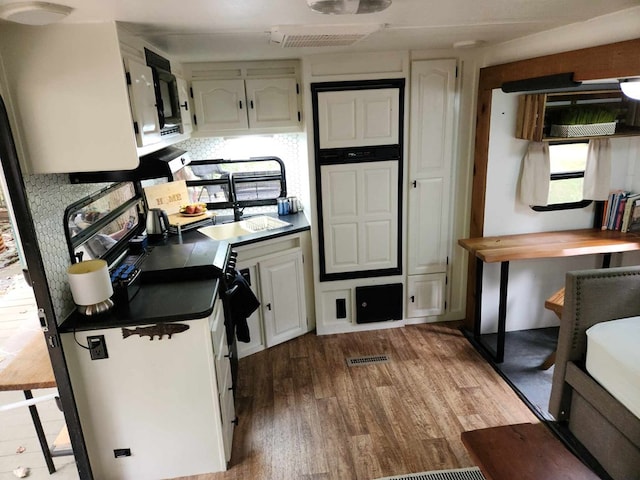 kitchen with backsplash, light hardwood / wood-style floors, and white cabinetry