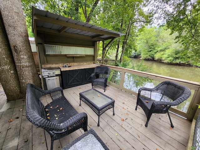 wooden terrace featuring area for grilling and sink