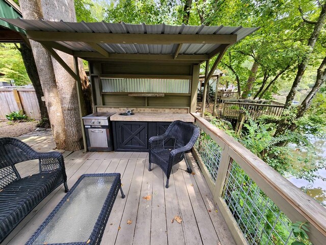 wooden terrace featuring area for grilling and sink