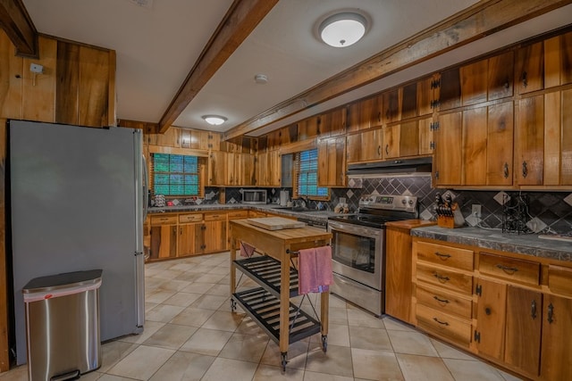 kitchen featuring stainless steel appliances, tasteful backsplash, beam ceiling, sink, and light tile floors