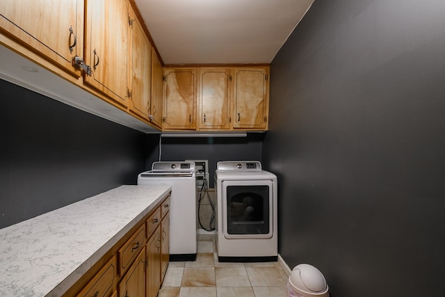 laundry area featuring independent washer and dryer, light tile flooring, washer hookup, and cabinets