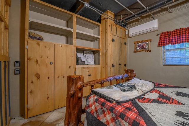 bedroom featuring light tile floors and a wall mounted air conditioner